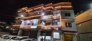 a tall building with cars parked in front of it at Hotel Ganpati place in Uttarkāshi