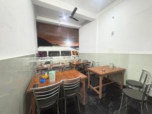 a dining room with tables and chairs and a bus at Hotel Ganpati place in Uttarkāshi