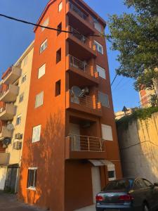 an orange building with a car parked in front of it at Green Oasis Budva in Prijevor