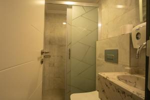 a bathroom with a shower with a toilet and a sink at Artemis Hotel in Bodrum City