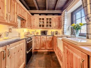 a kitchen with wooden cabinets and a large window at Yr Hen Efail in Abergorlech