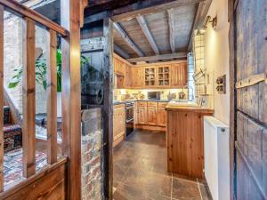 a kitchen with wooden cabinets and a sink at Yr Hen Efail in Abergorlech