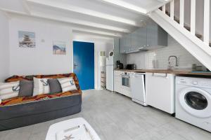 a living room with a couch and a kitchen at Maisonnette de la mer Batz sur mer in Batz-sur-Mer