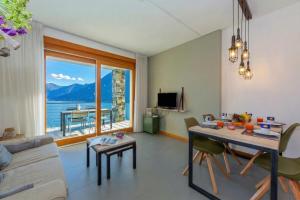 a living room with a table and a view of the ocean at Residence degli Oleandri 2A in Argegno +32 photos