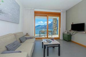 a living room with a couch and a view of the ocean at Residence degli Oleandri 2A in Argegno