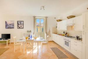 a kitchen with a table and chairs and a kitchen with white cabinets at Casa Al Prato Apt. F in Varenna