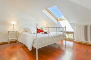 a bedroom with a white bed and a window at Casa Al Prato Apt. F in Varenna +24 photos