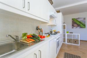 a kitchen with a sink with vegetables on a cutting board at Casa Al Prato Apt. F in Varenna