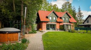 a house with an orange roof and a lawn at Rudziaszka in Otole