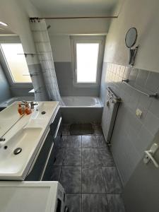 a bathroom with a tub and a sink and a bath tub at Appart cosy porte de Bâle - Terrasse - Parking - Tram in Saint-Louis