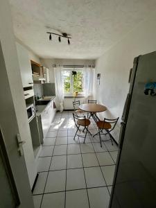 a kitchen with a table and chairs in a room at Appart cosy porte de Bâle - Terrasse - Parking - Tram in Saint-Louis