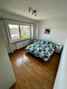 a bedroom with a bed and a large window at Appart cosy porte de Bâle - Terrasse - Parking - Tram in Saint-Louis