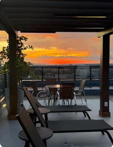 a patio with chairs and a table and a sunset at Flat Innerbloom Manaus in Manaus