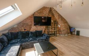 a living room with a couch and a brick wall at Appartement Proche Touquet in Étaples