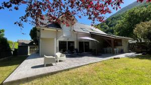 a patio with two white chairs and a house at Villa CASA COSY - Moderne - Climatisation - 3 chambres - 3 salles de bain in Saint-Mamet