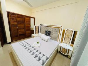 a bedroom with a large white bed in a room at QD Apartment Simba Unit in Arusha +1 photo