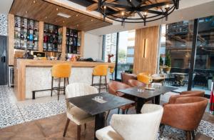 a restaurant with tables and chairs and a bar at Hedonist Wellness & Spa in Zlatibor