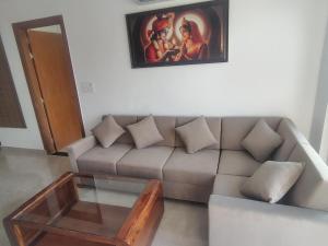 a living room with a couch and a painting on the wall at Ganga Bliss in Rishīkesh