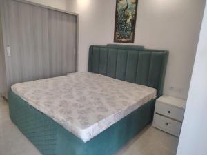 a bed with a green headboard in a bedroom at Ganga Bliss in Rishīkesh