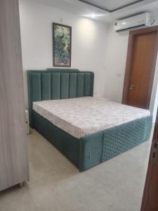 a bed in a room with a green bed frame at Ganga Bliss in Rishīkesh