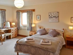 a bedroom with a bed with two towels on it at The Paddock in Saint Hilary +12 photos