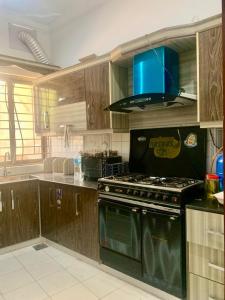 a kitchen with a stove and a blue at Cozy Corner Two-Bedroom in Abbottabad
