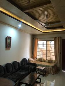 a living room with a couch and a window at Cozy Corner Two-Bedroom in Abbottabad