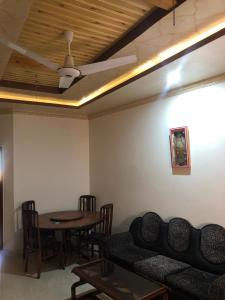 a living room with a couch and a table at Cozy Corner Two-Bedroom in Abbottabad