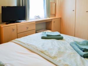 a bedroom with a bed with a tv and towels at Yolo Retreat in Felton