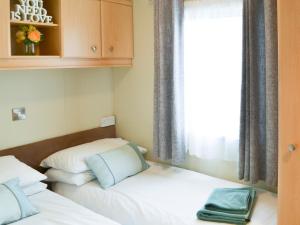 two beds in a small room with a window at Yolo Retreat in Felton