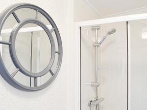 a round mirror hanging on a wall next to a shower at Yolo Retreat in Felton +3 photos
