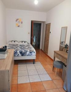 a bedroom with a bed and a desk and a table at Maison de ville in Pont-Saint-Esprit