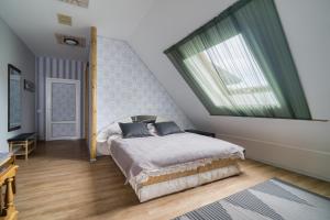 a bedroom with a bed and a large window at Jūras Vilks in Ventspils