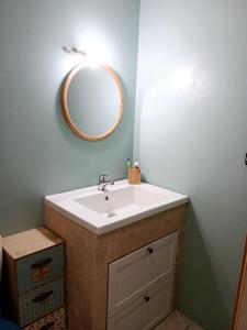 a bathroom with a sink and a mirror on the wall at Maison de ville in Pont-Saint-Esprit