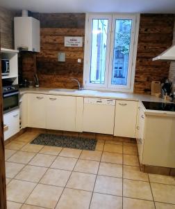 a kitchen with white cabinets and a sink and a window at Maison de ville in Pont-Saint-Esprit