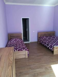 two beds in a room with wooden floors at GuestHous LUKA in Manglisi +7 photos