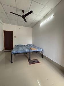 a room with a table with a ceiling fan at Mousumi Lodge in Tezpur