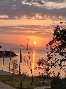 a sunset over a body of water with umbrellas at Gorgora Eco Resort in Gorgora +6 photos