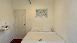 ein Zimmer mit zwei Betten und einem Gemälde an der Wand in der Unterkunft KINBOSHI Inn in Bangkok + 4 Fotos