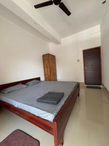 a bedroom with a bed with a ceiling fan at Mousumi Lodge in Tezpur