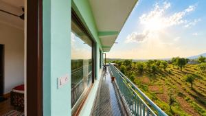 a balcony in a house with a view of the mountains at Aahista Stays- Mountain view homestay in Bīr