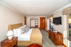 a bedroom with a bed and a flat screen tv at 36 Alexander Guesthouse,Highlands,Harare in Highlands