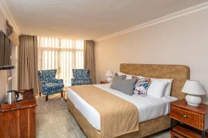 a hotel room with a bed and a chair at 36 Alexander Guesthouse,Highlands,Harare in Highlands +14 photos