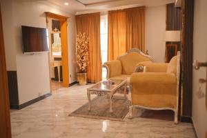 a living room with two chairs and a coffee table at Burj A Zafar in Murree