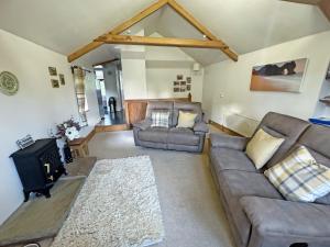 a living room with a couch and a stove at Valley View in Burnsall