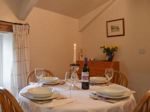 a dining room table with a bottle of wine and glasses at Valley View in Burnsall