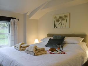 a bedroom with a white bed with towels on it at Valley View in Burnsall +3 photos