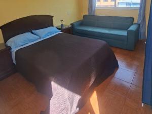 a bedroom with a large bed and a couch at Terraza Amecameca in Amecameca de Juárez