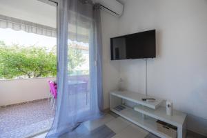 a white room with a tv and a window at Apartments Villa Rotim in Zadar