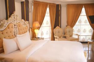 a bedroom with a large white bed and two chairs at Burj A Zafar in Murree +51 photos
